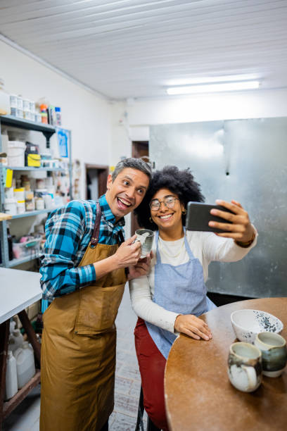 Coworkers taking selfie at ceramics workshop