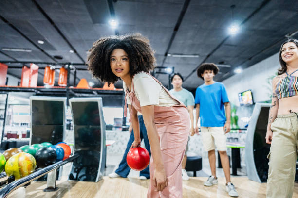istock Young woman playing bowling on a bowling alley 2153050565