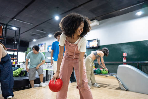 istock Young woman playing bowling on a bowling alley 2153050771