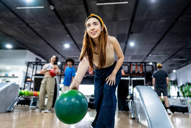 istock Young woman playing bowling on a bowling alley 2153050852