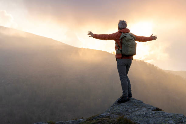 istock Mature hiker pauses on rock above misty hills 2153050968