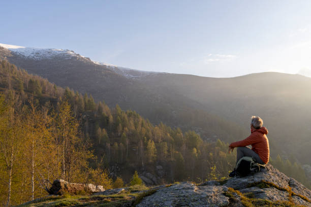 istock Mature hiker pauses on rock above misty hills 2153051197