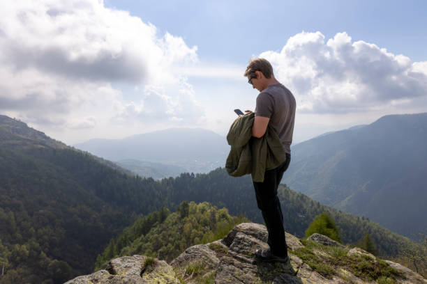 istock Young man uses mobile phone on hill 2153051476