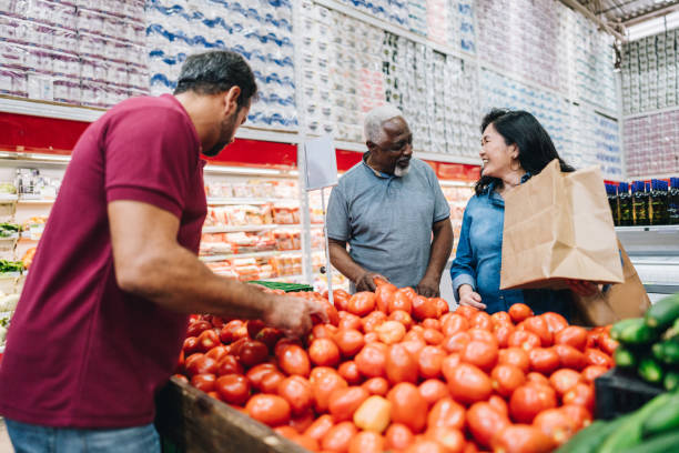 istock Senior couple customers talking while choosing tomatoes at the supermarket 2153051784
