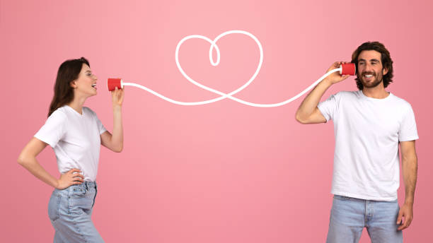 istock A young couple playfully communicates through tin can telephones connected 2153052249