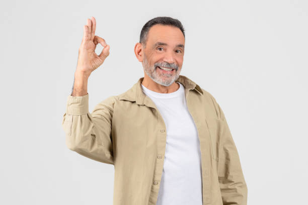 Man in White Shirt and Tan Jacket Making Okay Sign