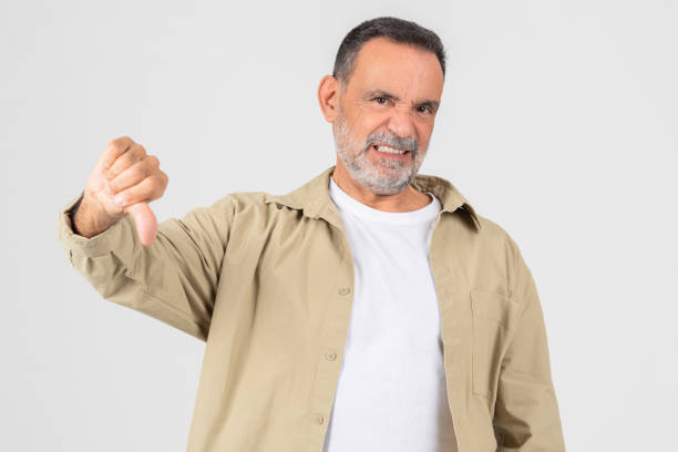 istock Man in White Shirt and Tan Jacket Showing Thumb Down 2153052409