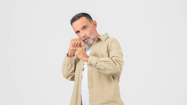 istock Man in Tan Shirt Holding Hands Together In Fighting Pose 2153052419
