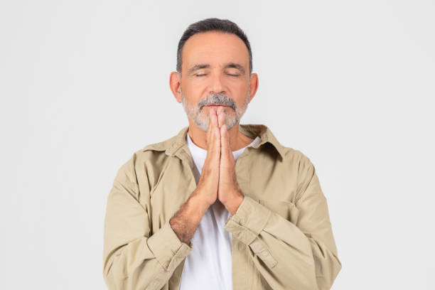 istock Senior man in prayer gesture isolated on white 2153052519