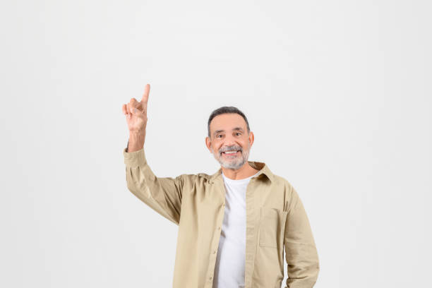 istock Senior man joyfully pointing upwards at copy space 2153052531