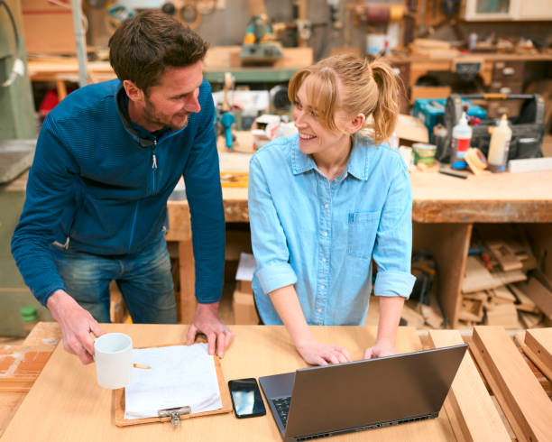 istock Male And Female Carpenters Working In Woodwork Workshop Using Laptop Together 2153060885