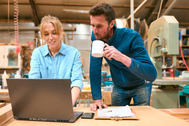 istock Male And Female Carpenters Working In Woodwork Workshop Using Laptop Together 2153061071