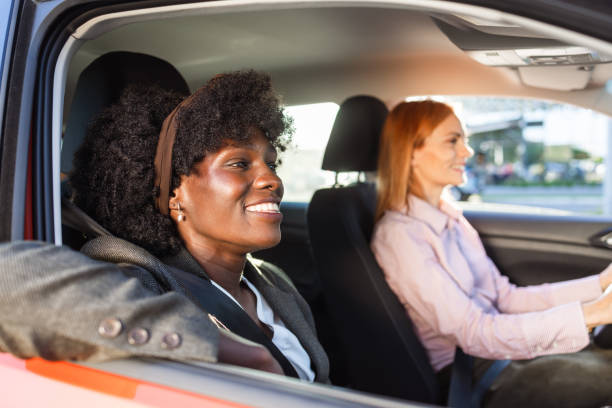 istock Two women smiling while driving together in a car 2153064086