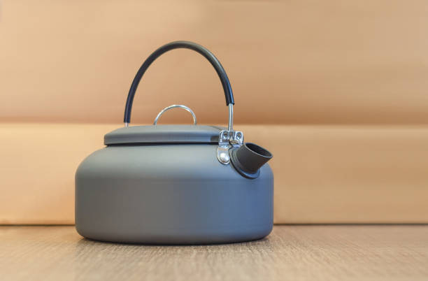 istock Clear design of camping kettle with black handle, on beige background. Concept recreation and hiking 2153064372