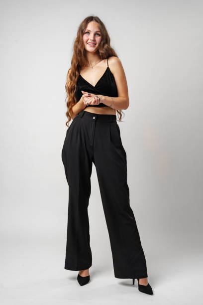istock Young Woman in Elegant Black Attire Posing in Studio Against a Neutral Backdrop 2153065046