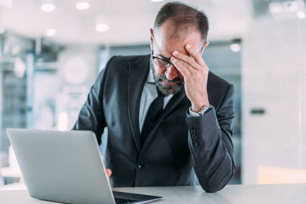 istock Stressed businessman having headache while working on laptop in the office. 2153071989