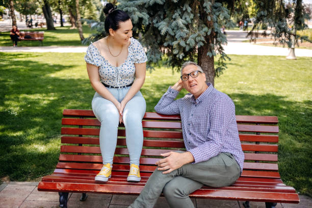 istock 50 year old man spending quality time with his university student daughter outdoors in public park and talking 2153074665