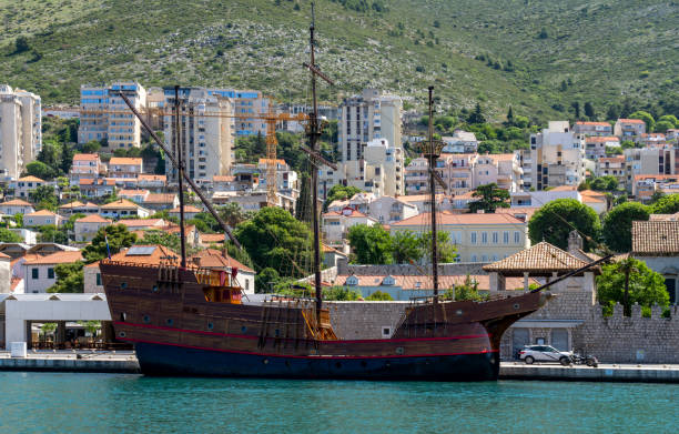 Dubrovnik Croatia - May 28 2011;T ourists sighteeing from Old Harbour on tourist boats boat in harbour surrounded by medieval stone walls of Old Town.