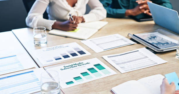 istock Business hands, documents and notes on graphs, charts and statistics for market research. Colleagues, data analyst with feedback or project management, plan and teamwork for growth ideas in meeting 2153079807