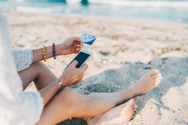 istock Woman at the beach shopping online with credit card 2153080708