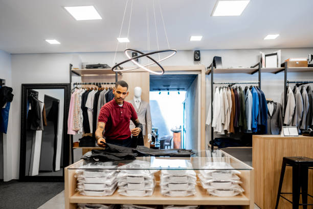 istock Salesman folding clothes at the store 2153081147