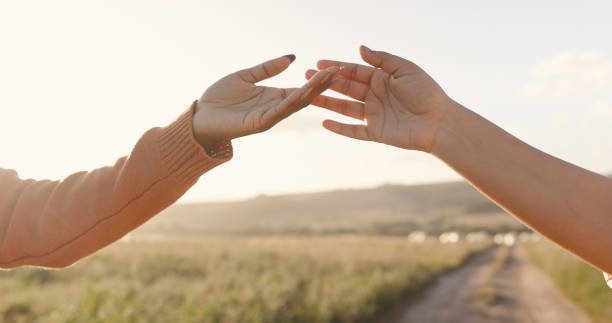 istock People, hands and connection in sunset love for holiday bonding, romance or affection. Couple, fingers and touching on vacation for honeymoon together or outdoor sunshine, partnership or marriage 2153082552