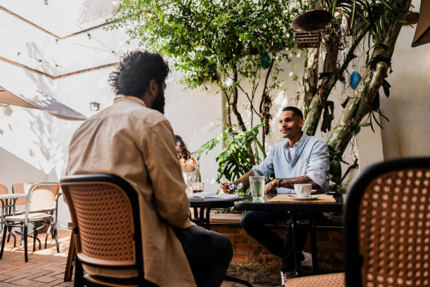 istock Young man talking with friend at coffee shop 2153082605