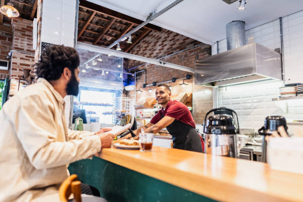 istock Young waiter talking with customer at coffee shop 2153083700