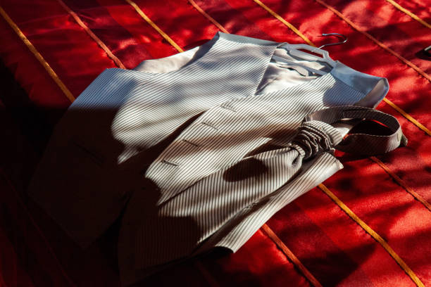 Groom's suit vest and tie laid on bed, pre-wedding. Elegant ensemble for groom's attire.