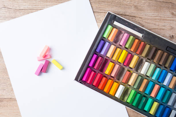 Painting, crayons and paper on a wooden table
