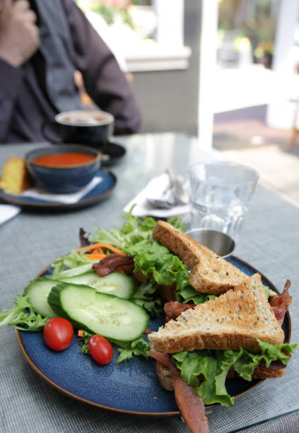 Selective focus on a bacon, lettuce and tomato sandwich with a salad in a Metro Vancovuer cafe.