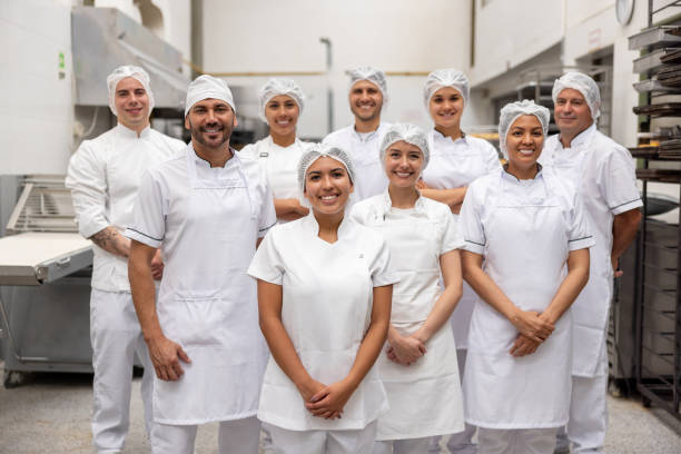 istock Group of workers smiling at an industrial bakery 2153090537