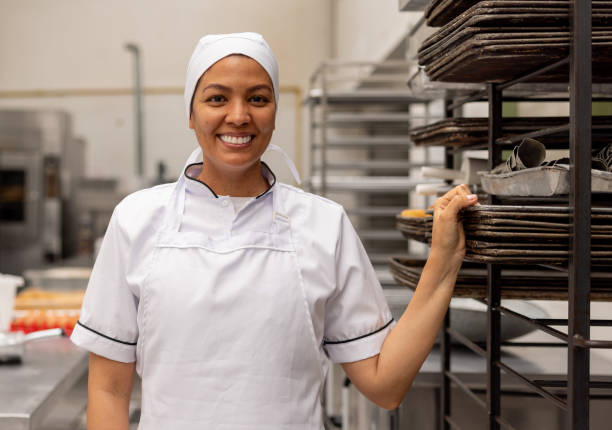 istock Woman working at an industrial bakery and smiling 2153090551