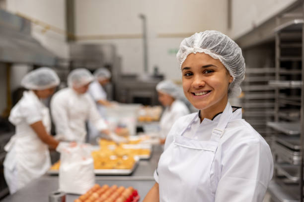 istock Female baker working at an industrial bakery and smiling 2153090566