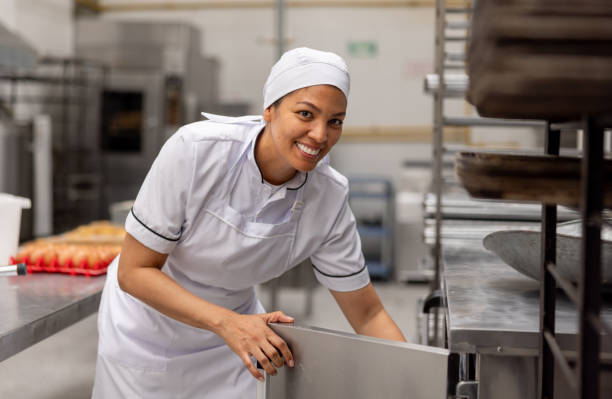 istock Woman working at an industrial bakery and smiling 2153090583