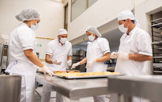 istock Group of bakers working at a donut factory 2153090637