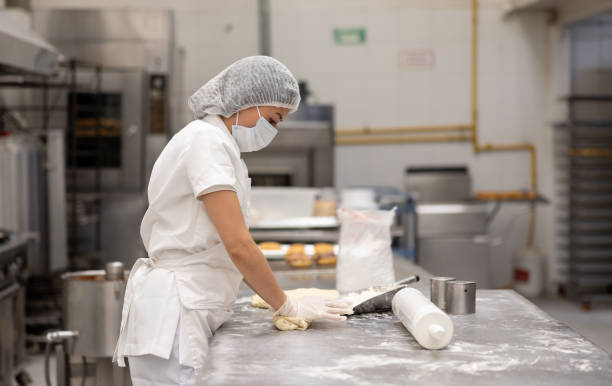 istock Baker kneading the dough at an industrial bakery 2153090694