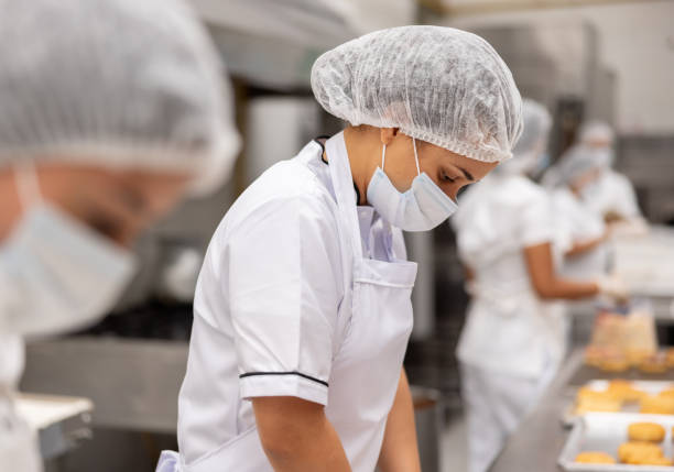 istock Woman working at a food processing plant wearing protective workwear 2153090989