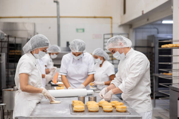 istock Group of bakers working at a donut factory 2153091224