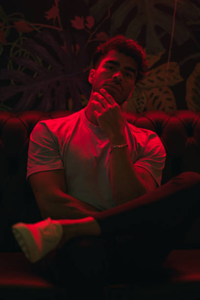 istock Man in a dark lounge under red neon light at night 2153092696