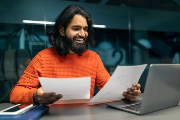 istock Happy millennial indian manager checking report at office 2153094196