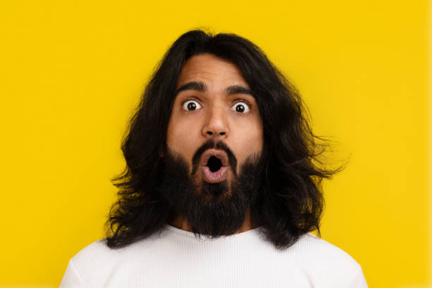 istock Portrait of shocked indian guy posing on yellow studio background 2153096816