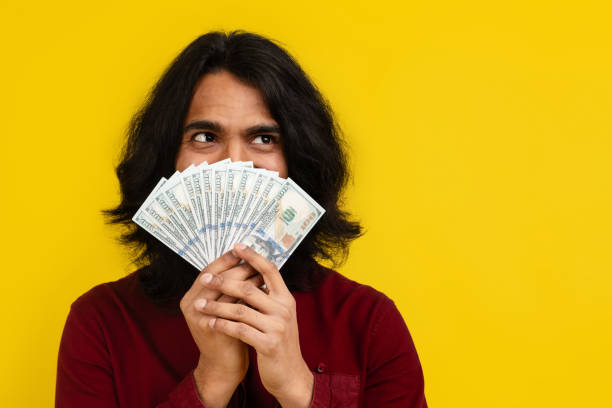 istock Eastern man hiding behind cash fan, looking at copy space 2153096861