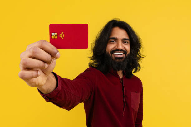 istock Cheerful young indian guy showing bank card 2153096888