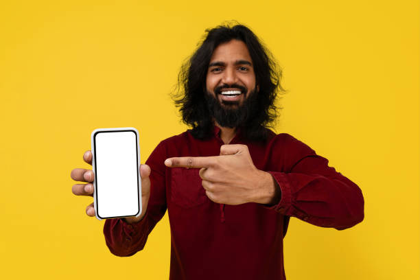 istock Positive hindu guy showing cell phone with white empty screen 2153096892