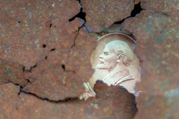 A coin with a face on it is seen through a hole in a wall. The image has a sense of mystery and intrigue