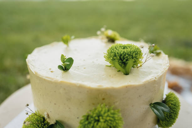 A beautifully decorated white cake featuring intricate green flowers on top, creating a stunning and elegant centerpiece.