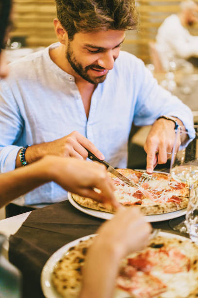 istock Young Man Enjoying Pizza in a Restaurant - Casual Dining 2153104804