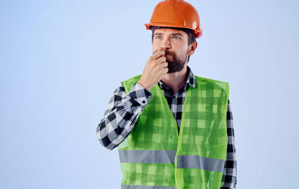 istock a construction worker in a helmet gestures with his hands and a reflective vest 2153105738