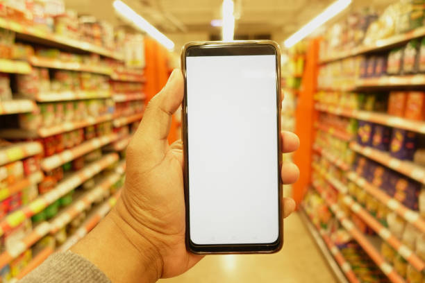 istock hand holding mobile phone with white screen while shopping at supermarket. 2153106939